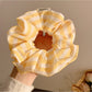Yellow striped scrunchie displayed flat showing full circular shape