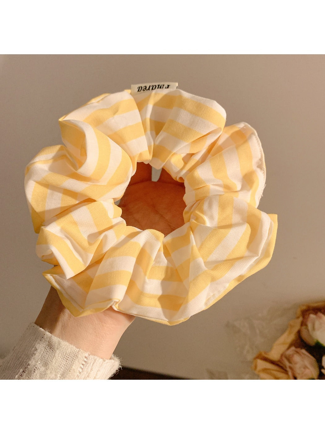 Yellow striped scrunchie displayed flat showing full circular shape