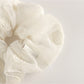 Multiple Gifty scrunchies in different colors displayed on a white surface