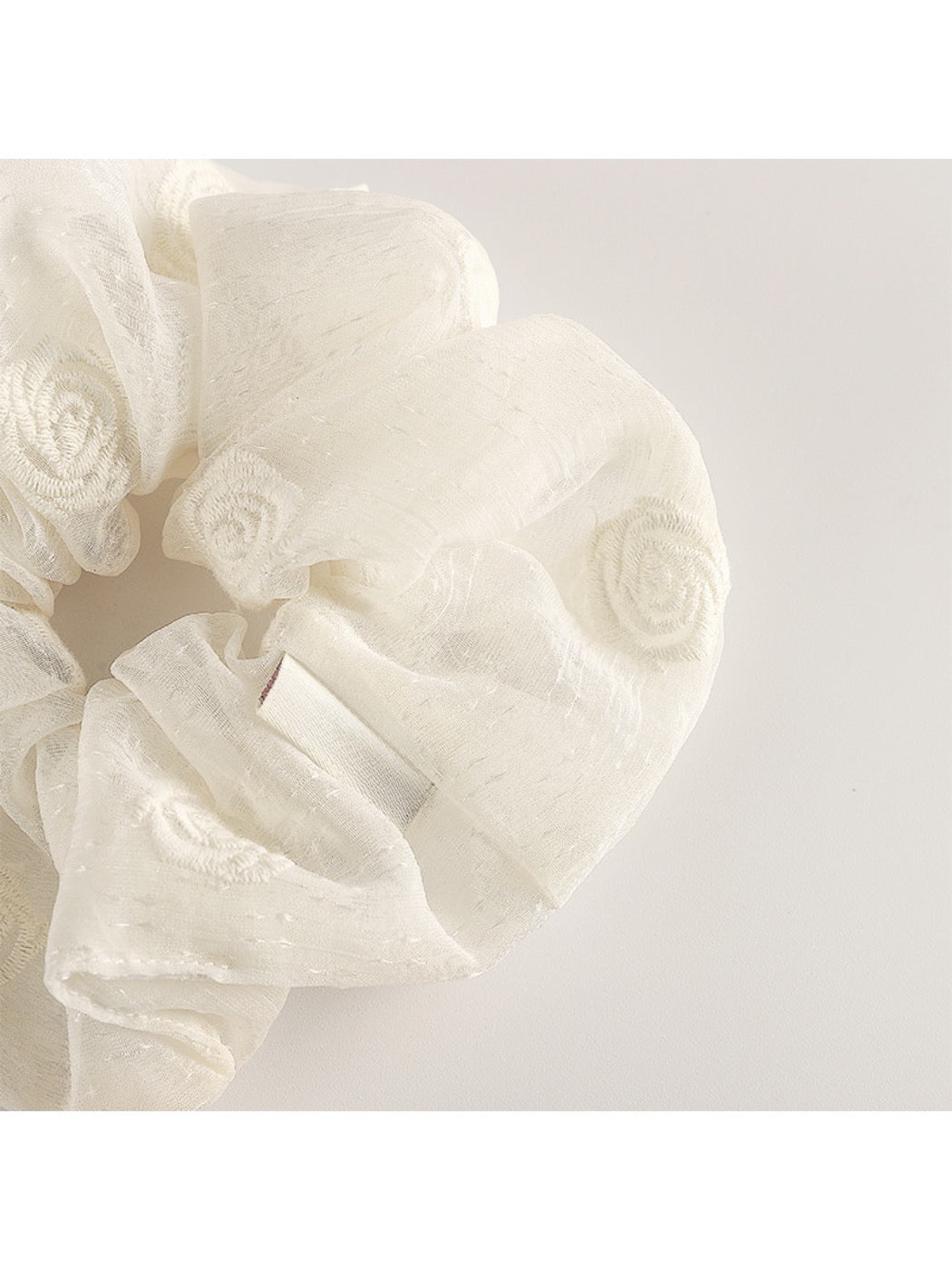 Multiple Gifty scrunchies in different colors displayed on a white surface