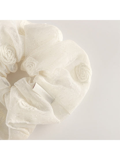 Multiple Gifty scrunchies in different colors displayed on a white surface