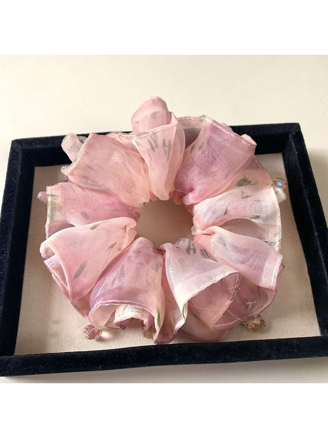 Pink ruffled scrunchie placed next to matching vintage-inspired accessories