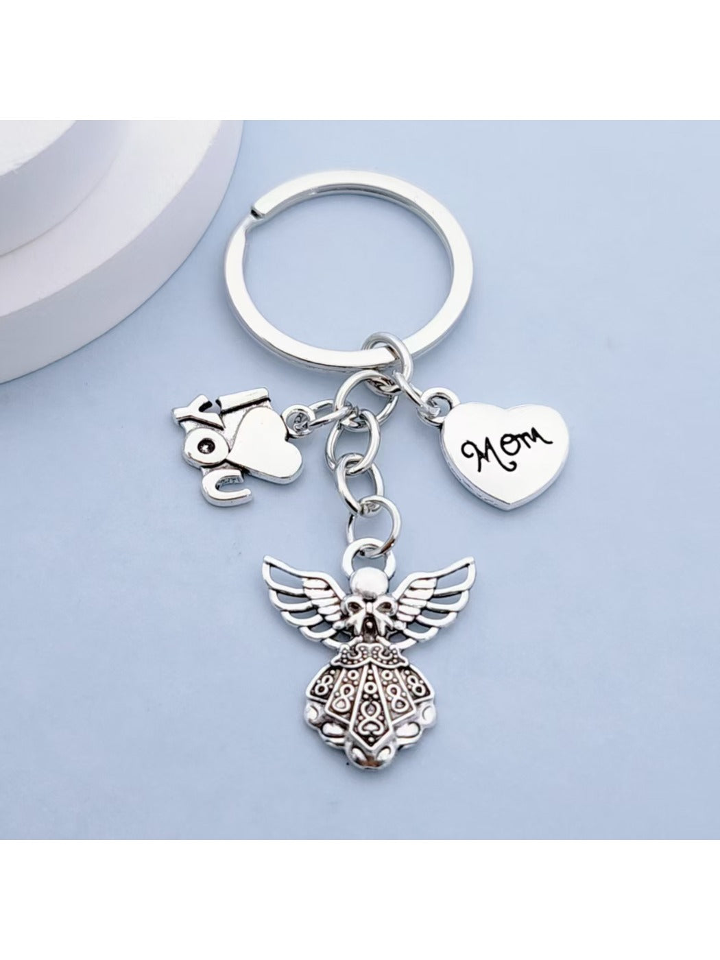 Side view of shiny alloy angel keychain showing smooth finish