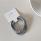 Side view of Gifty satin hair tie highlighting elastic stretch and fabric