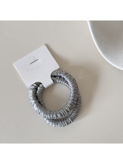 Side view of Gifty satin hair tie highlighting elastic stretch and fabric