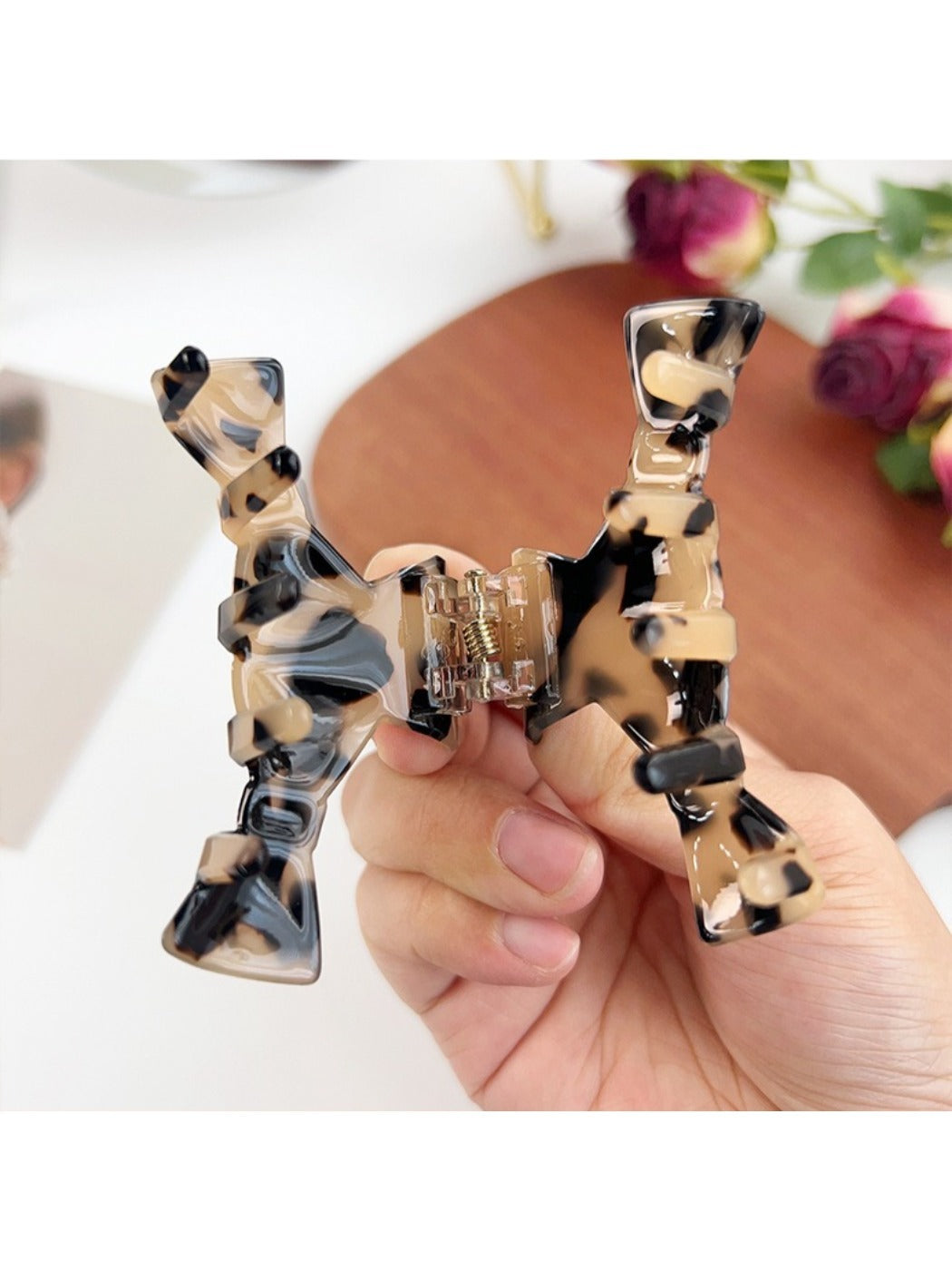 Beau bow shaped claw clip open, showing metal spring mechanism