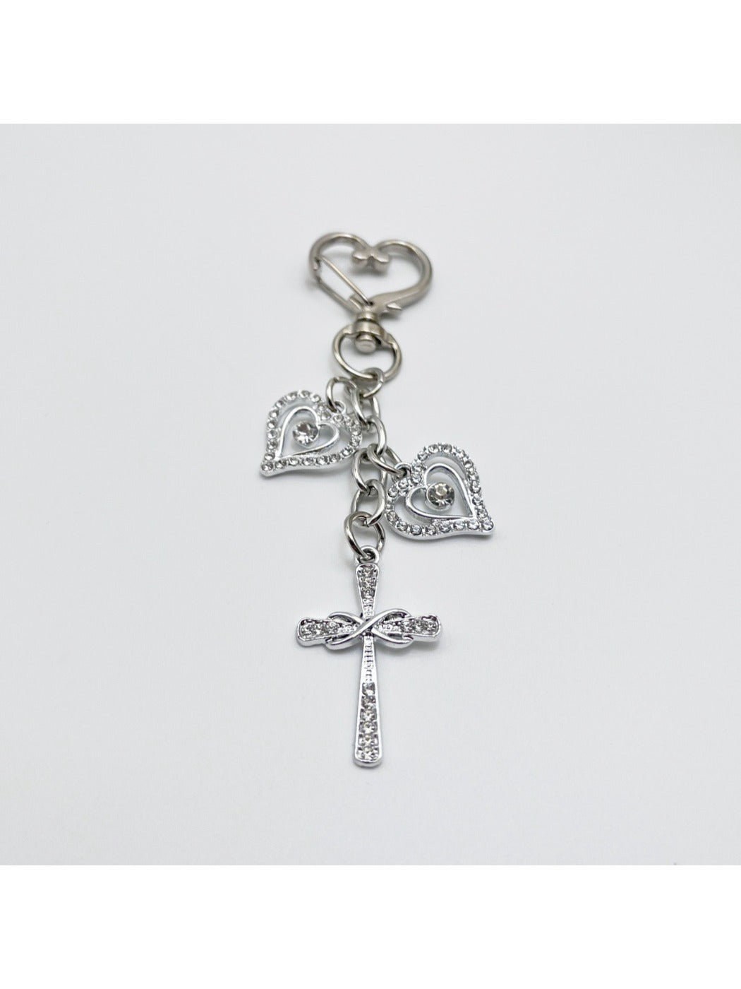 Vintage cross pendant keychain displayed on a wooden surface