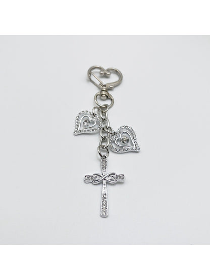 Vintage cross pendant keychain displayed on a wooden surface