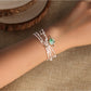 Lovra minimalist multi strand bracelet with small round beads in neutral tones on a white background