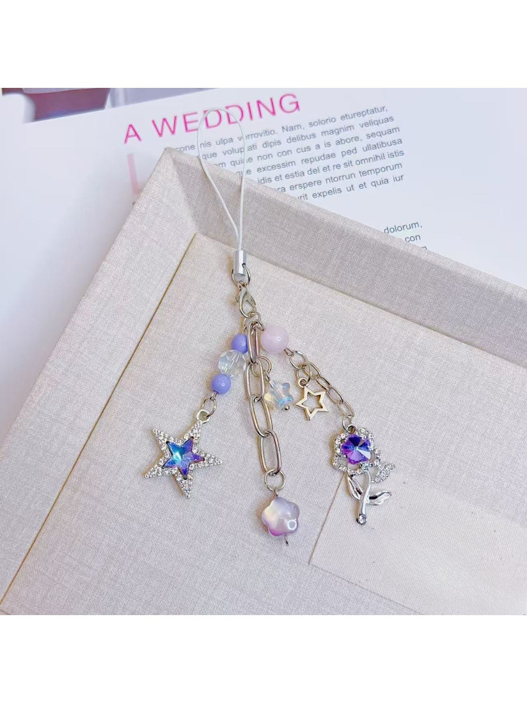 Purple star flower charm keychain displayed on a white background