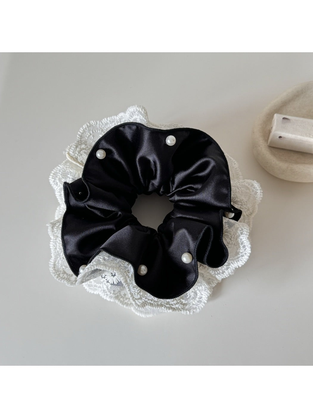 Beige lace trim satin scrunchie styled in a woman's hair