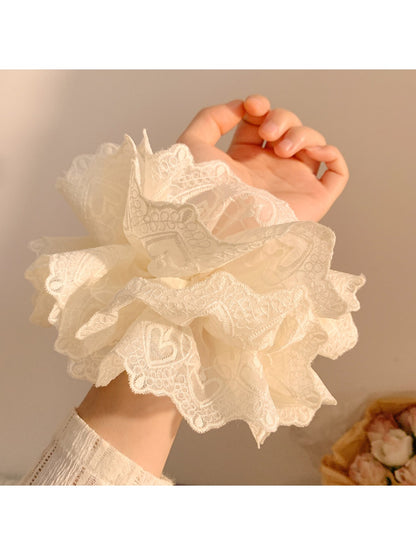 Close-up of white ruffled scrunchie showing soft, fluffy texture
