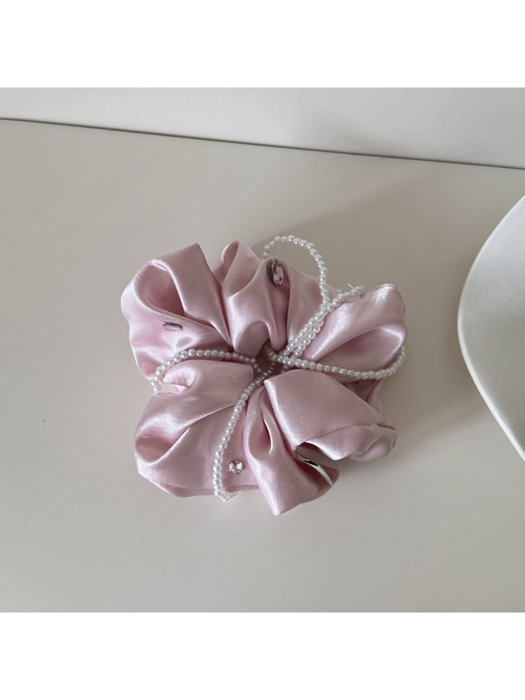 Gifty satin scrunchie styled on a wrist as a chic accessory