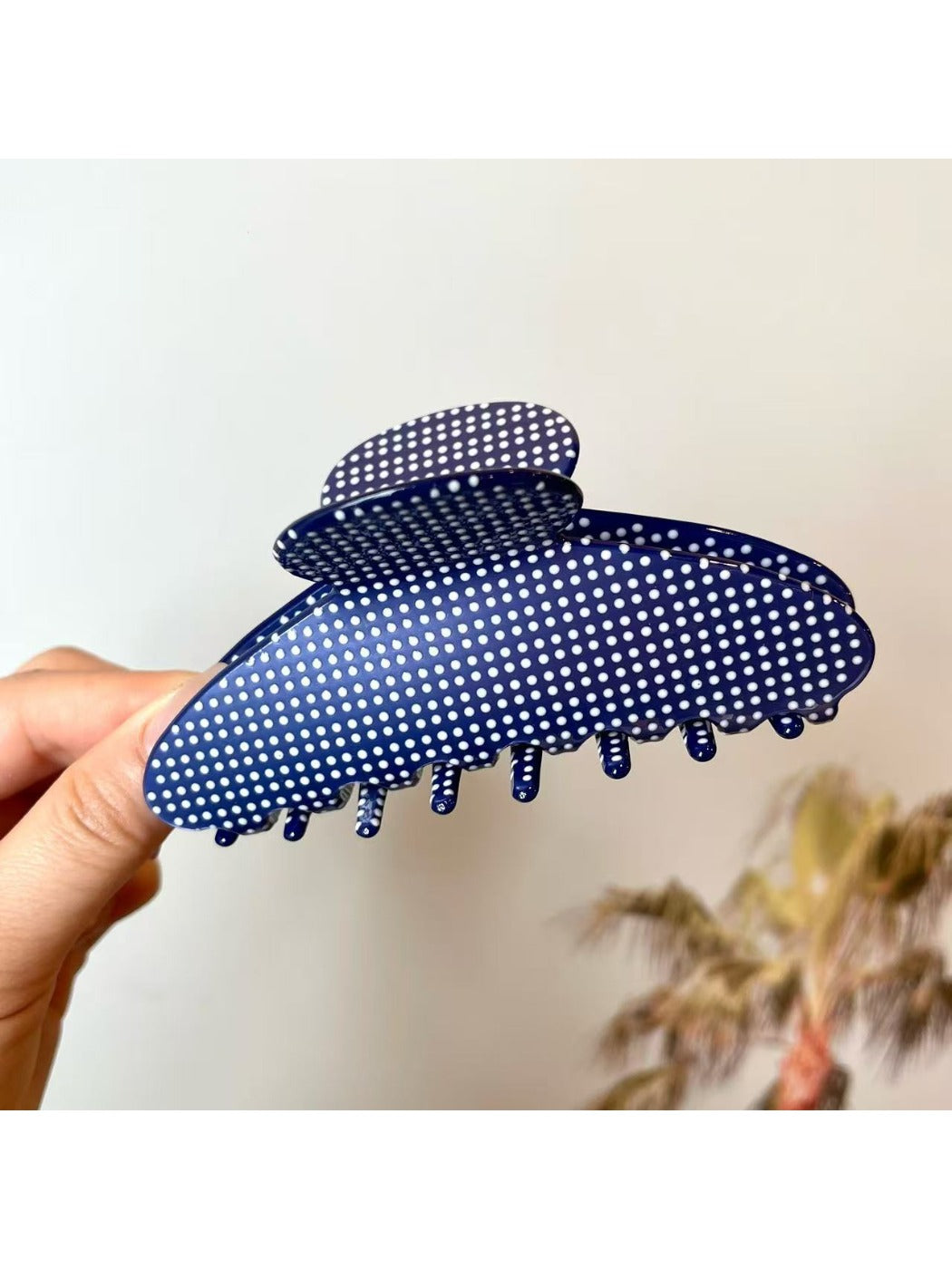 Beau polka dot acetate claw clip angled to show glossy finish and polka dots