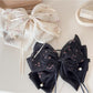 Beau elegant hair claw clip with a large bow accent in glossy black finish