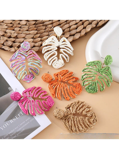 Close-up of Earedge raffia woven hollow leaf shaped earring on white background