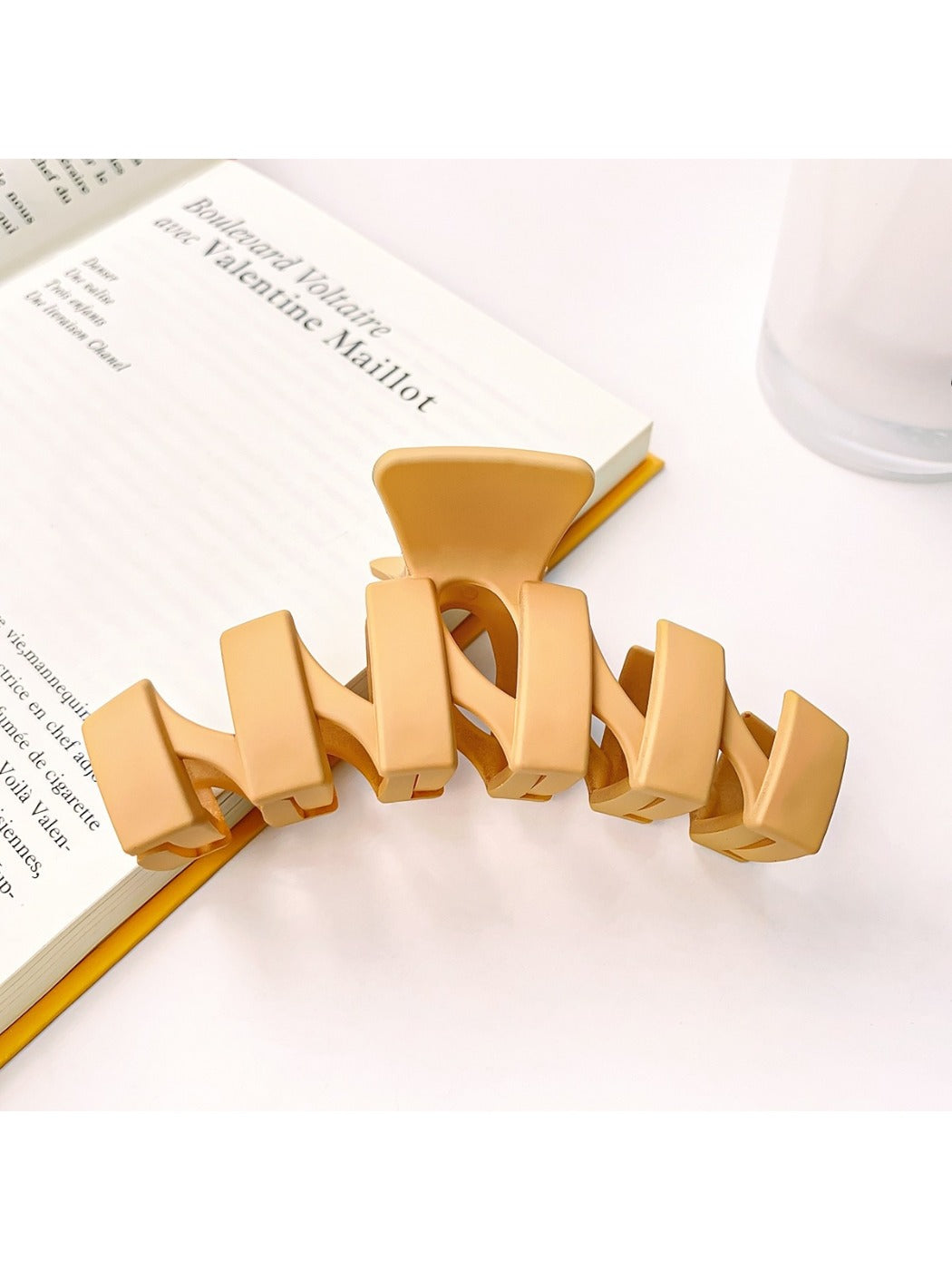 Beau hair claw clip resting on wooden surface highlighting matte finish