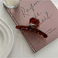 Beau elegant chic claw clip resting on a wooden surface with soft lighting