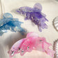 Butterfly hair claw clip open, displaying metal spring mechanism