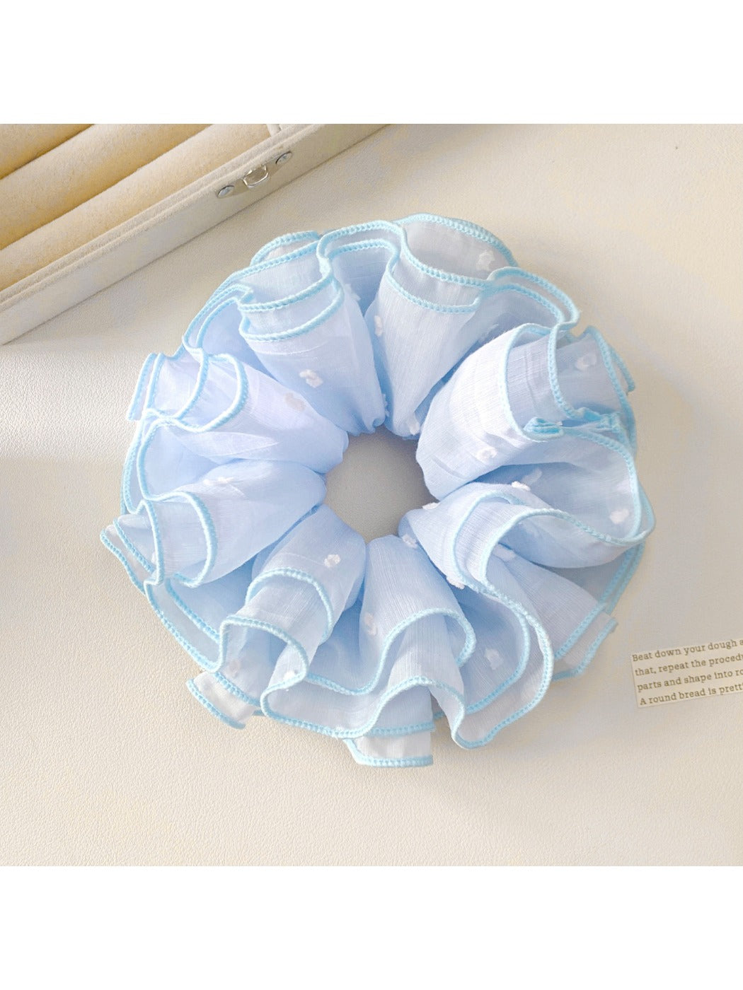 Gifty minimalist scrunchie in pastel pink paired with casual outfit on model's wrist