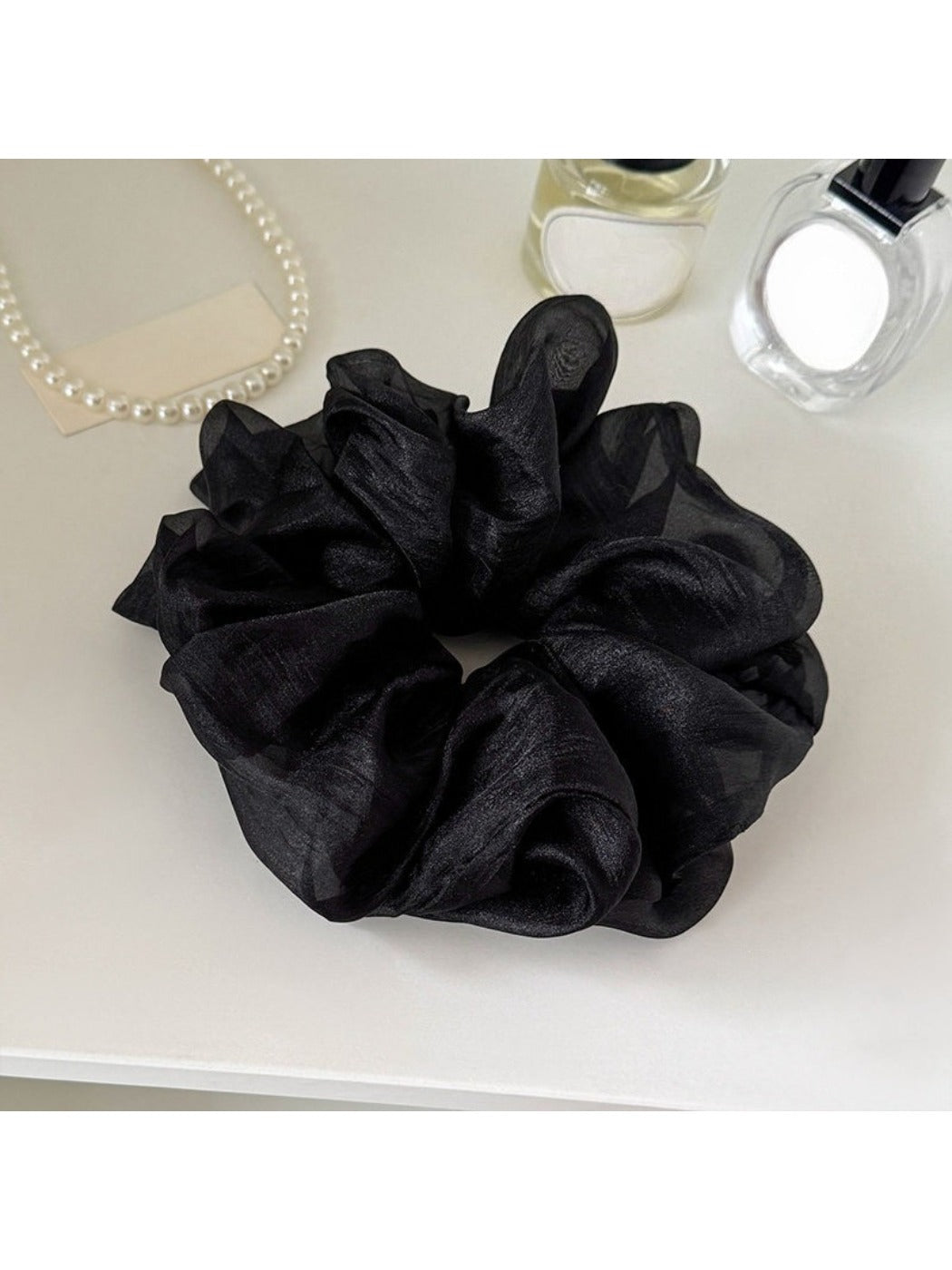 Multiple solid color scrunchies stacked together showing variety