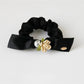 Model wearing Gifty floral hair tie in a loose bun hairstyle outdoors