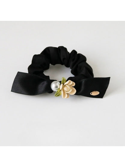 Model wearing Gifty floral hair tie in a loose bun hairstyle outdoors
