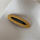 Beau hair clip held between fingers showing size and detail