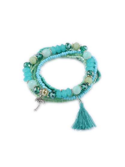 Side view of Lovra multi-row beaded bracelet highlighting tassel charms