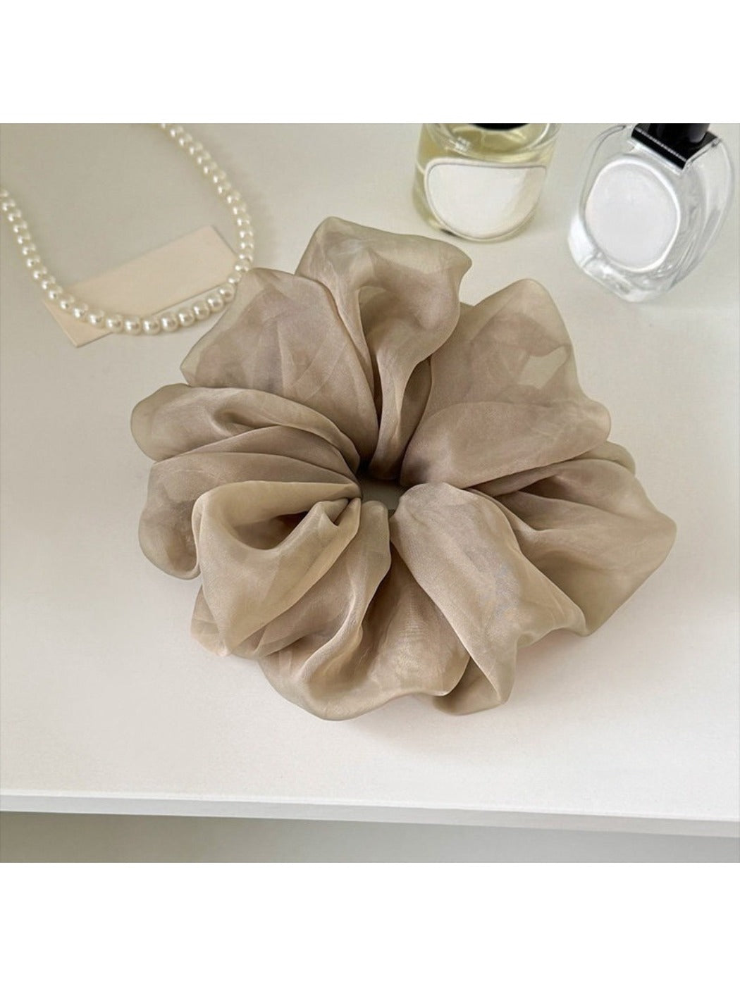 Gifty ruched scrunchie styled with casual outfit on a mannequin