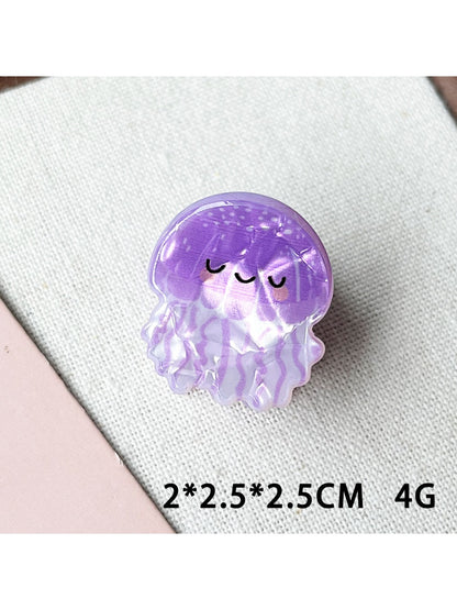 Beau claw clip held in hand displaying colorful shark and octopus artwork
