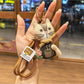 Keychain with vintage cat charm attached to a metal keyring on wooden background