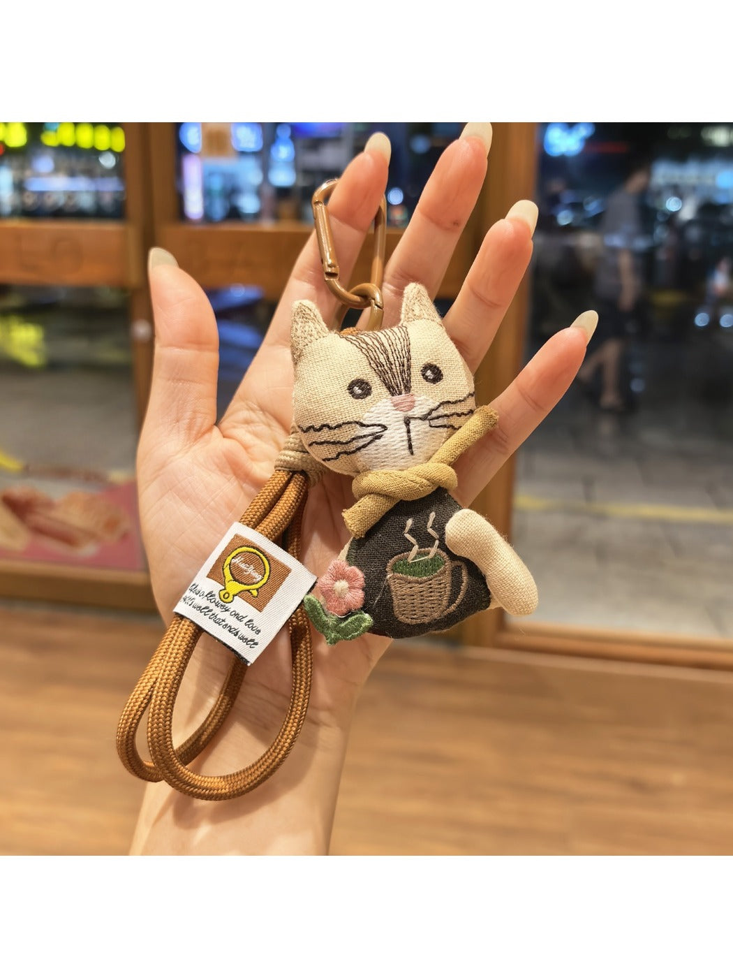 Keychain with vintage cat charm attached to a metal keyring on wooden background