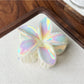 Beau flower shaped claw clip with petals spread open on white background