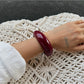 Model wearing Lovra red ombre link bracelet and ring on wrist and finger