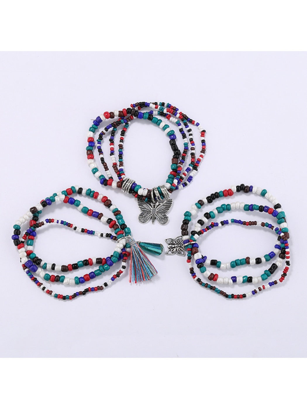 Close-up of butterfly pendant showing intricate gold detailing on beaded bracelet
