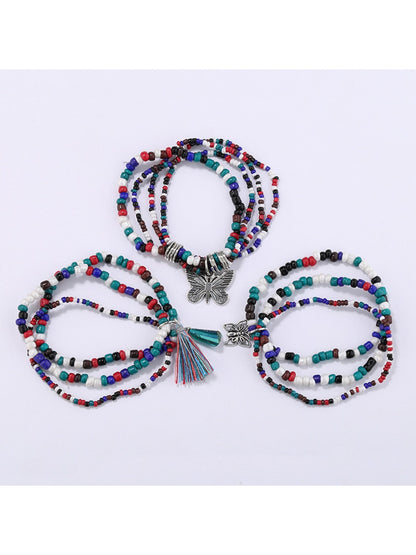 Close-up of butterfly pendant showing intricate gold detailing on beaded bracelet