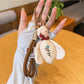 Bee charm keychain attached to a set of keys on a wooden surface