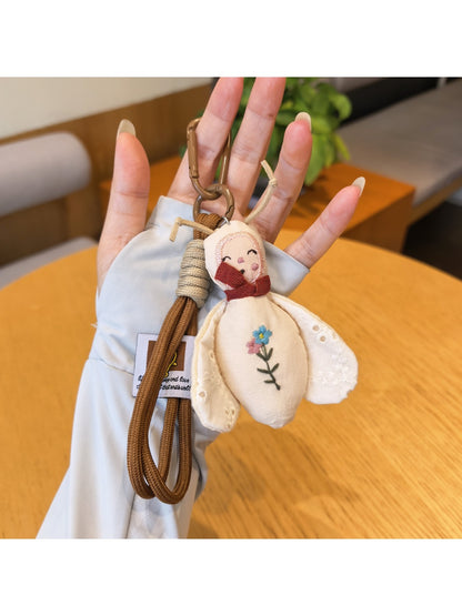 Bee charm keychain attached to a set of keys on a wooden surface