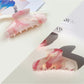 Beau hair claw clip resting on a wooden surface with natural lighting