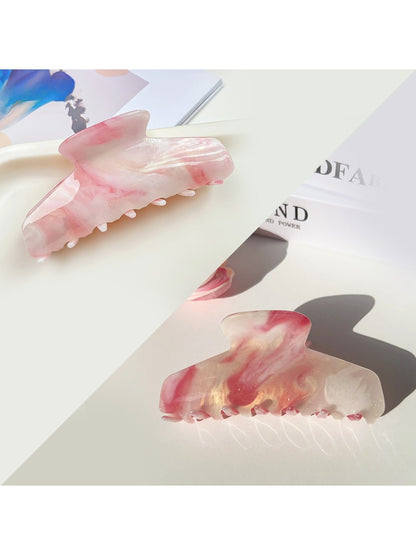 Beau hair claw clip resting on a wooden surface with natural lighting
