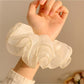 Side view of pastel pink tulle scrunchie highlighting layered design