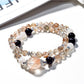 Lovra multi-wrap bracelet with black and gold crystals on a white background