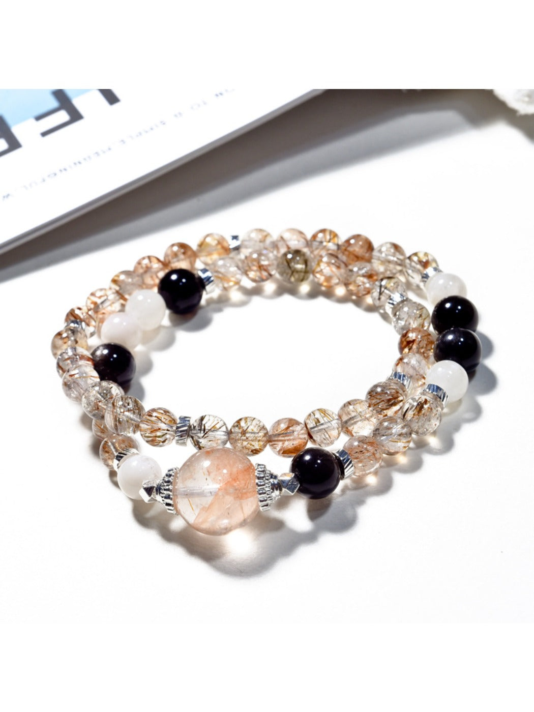 Lovra multi-wrap bracelet with black and gold crystals on a white background