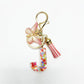 Butterfly letter pendant keychain held between fingers showing size