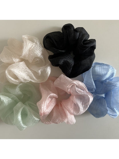 Minimalist sheer tulle scrunchie in soft beige on white background