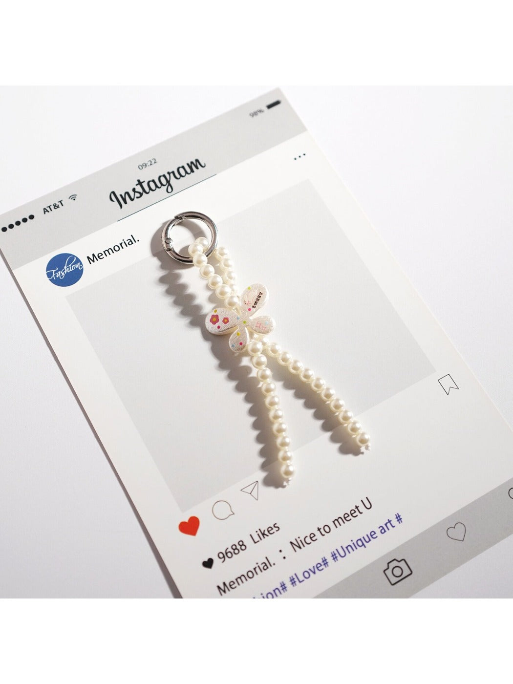 Keypus bow keychain displayed hanging from a hook with light background