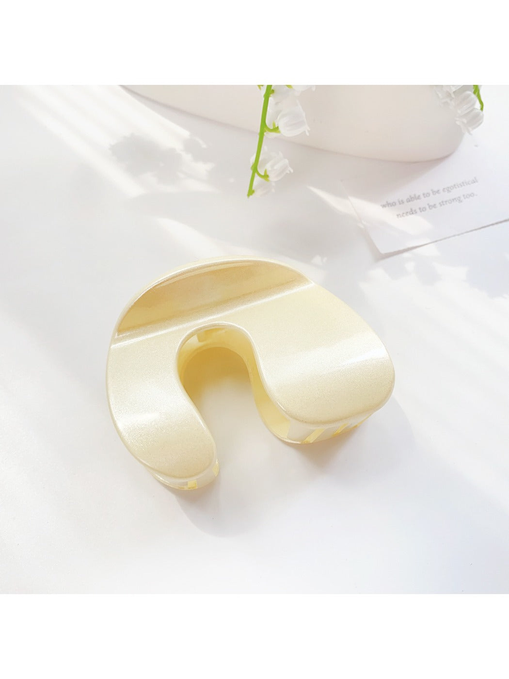 Beau hair claw clip in neutral color displayed with matching accessories