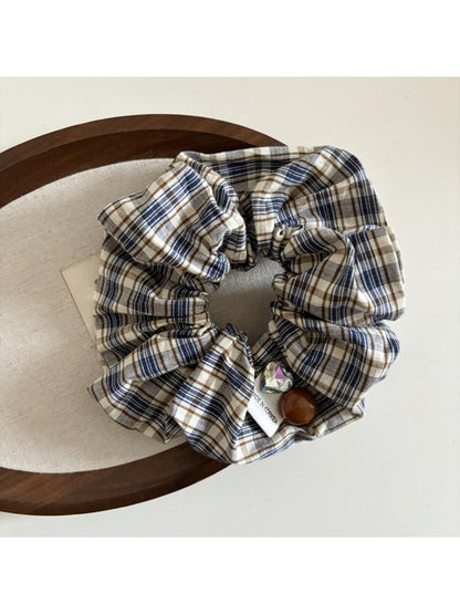 Flat lay of Gifty vintage plaid bow scrunchie with bow detail visible