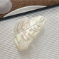 Beau hair claw clip displayed on a wooden surface with natural lighting